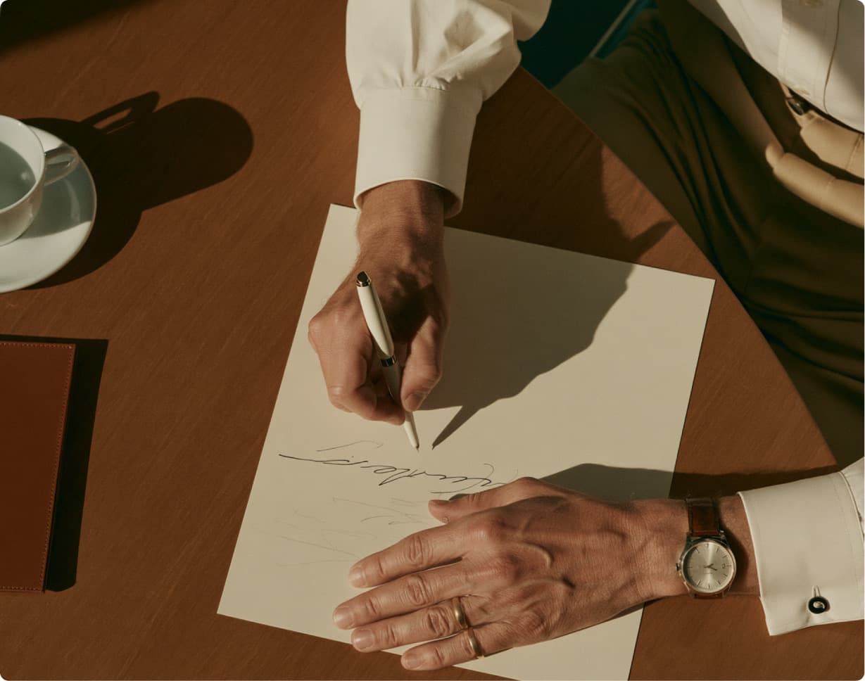 An advisor signing a document at a wooden desk